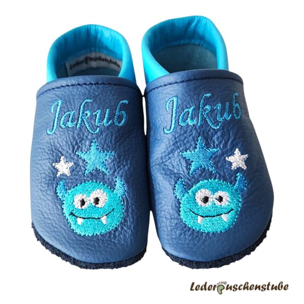 Lauflernschuhe personalisiert – Lederpuschen jeansblau-lichtblau, Namen beiderseits am Spann lichtblau, Monsterkopf mit 2 Sternen lichtblau/weiß